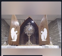 a wooden altar with an image of an angel and a crucifix